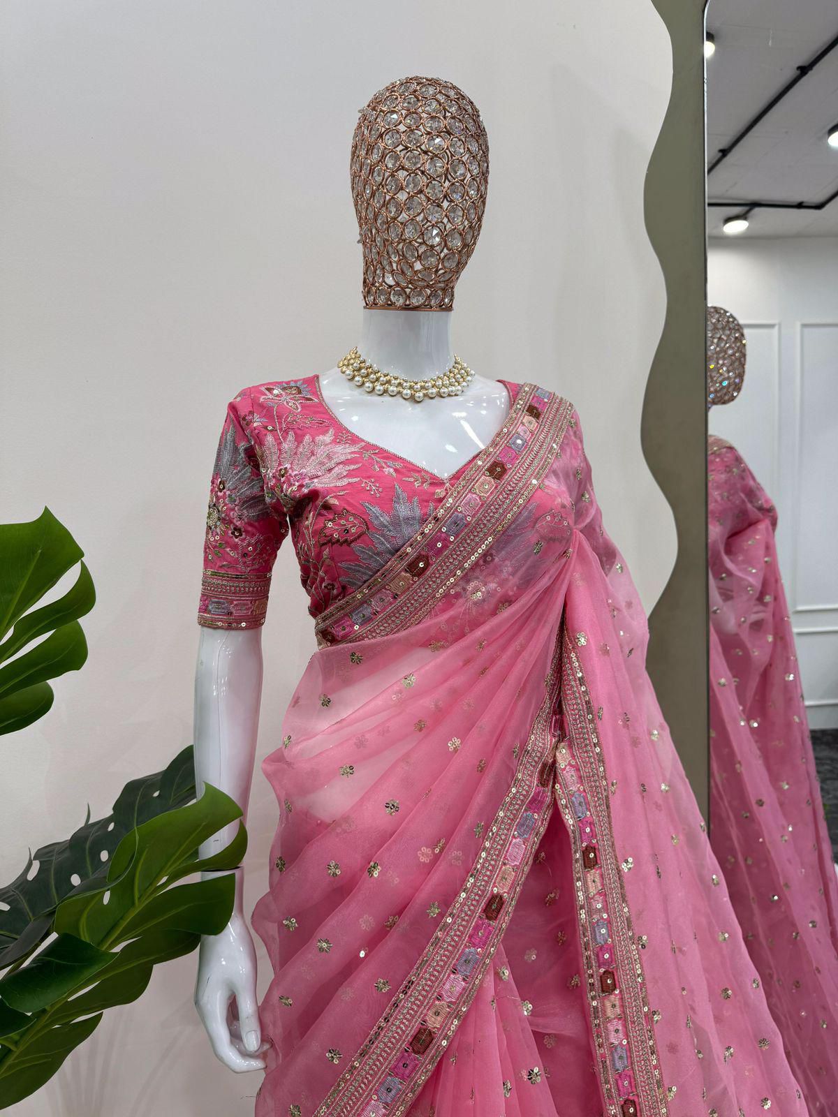 Mannequin wearing a pink saree with intricate designs in a store setting